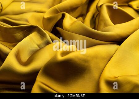 Fragment von gelbem und grünem Gewebe. Seitenansicht, synthetischer Textilhintergrund und Textur. Wellenkonzept, abstrakt. Stockfoto