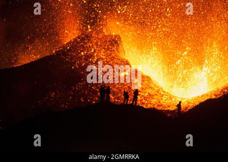 Touristen beobachten einen Vulkanausbruch, Island Stockfoto