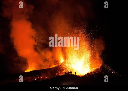 Touristen beobachten einen Vulkanausbruch, Island Stockfoto