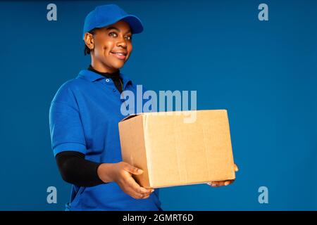 Schöne junge afrikanische Kurierarbeiterin mit einem Kasten Stockfoto