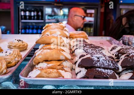 New York, New York, USA. September 2021. Italienische Bäckerei, die Cannolis zum Fest von San Gennaro Little Italy NYC verkauft. Die jährliche Feier in der Mulberry Street zur Feier des Schutzpatrons von Neapel, der sie vor Naturkatastrophen geschützt haben soll. Die Veranstaltung umfasst eine Prozession der Statue (Schrein) durch die Straßen und einen Straßenmarkt, der Tausende zu Würstchen, Pizza, Cannolis, Zeppolen und anderen beliebten italienischen Speisen zieht. (Bild: © Milo Hess/ZUMA Press Wire) Stockfoto