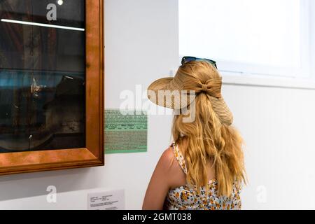 Hinter dem Fenster ist ein Museum mit Reliquien, Skulpturen und Töpferwaren aus den alten Zivilisationen Kappadokiens ausgestellt. Eine schöne junge Frau Stockfoto