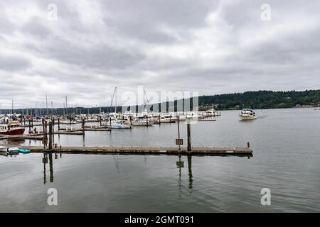 Legen Sie an einem bewölkten Tag an einer Marina mit Yachten und Segelbooten an Stockfoto