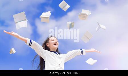 Glückliche Schüler werfen Bücher fliegen in der Luft Stockfoto