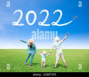 Glückliche Familie, die den Himmel beobachtet und Konzepte für das neue Jahr 2022 feiert Stockfoto