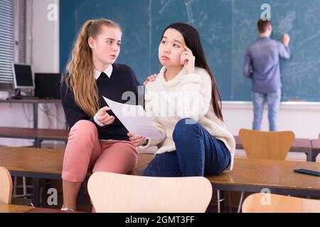 Teen weibliche Student Unterstützung verärgert chinesisches Mädchen im Klassenzimmer Stockfoto