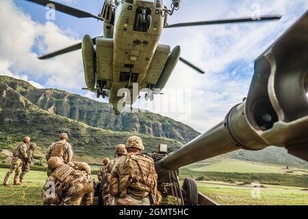 Chofield Barracks, HI – Soldaten von Charlie Battery „Copperheads“, 3. Bataillon, 7. Feldartillerie, 25th Infantry Division Artillery (25th DIVARTY) Sling beladen M777A2 Haubitzen auf einen CH-53E und führte einen gemeinsamen Luftangriff mit Marines vom Combat Logistics Bataillon 3 und Marine Heavy Helicopter Squadron 463 im Rahmen der Operation „Steel Crucible“ am 16. September 2021 von Schofield Barracks, Hawaii nach Makua Valley, Hawaii. Durch diese Übung wurde die gemeinsame Fähigkeit von Air Assault in einer Umgebung mit mehreren Domänen verbessert. Operation Steel Crucible ist ein umfassendes, komplexes 2-wöchiges Bataillon exe Stockfoto