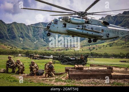 Chofield Barracks, HI – Soldaten von Charlie Battery „Copperheads“, 3. Bataillon, 7. Feldartillerie, 25th Infantry Division Artillery (25th DIVARTY) Sling beladen M777A2 Haubitzen auf einen CH-53E und führte einen gemeinsamen Luftangriff mit Marines vom Combat Logistics Bataillon 3 und Marine Heavy Helicopter Squadron 463 im Rahmen der Operation „Steel Crucible“ am 16. September 2021 von Schofield Barracks, Hawaii nach Makua Valley, Hawaii. Durch diese Übung wurde die gemeinsame Fähigkeit von Air Assault in einer Umgebung mit mehreren Domänen verbessert. Operation Steel Crucible ist ein umfassendes, komplexes 2-wöchiges Bataillon exe Stockfoto