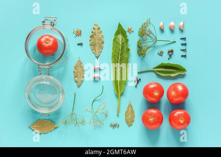 Eingelegte Tomaten. Zutaten für marinierte Tomaten und Glas auf blauem Hintergrund. Konzept kulinarische Rezept Konservierung von Gemüse in der Ernte s Stockfoto