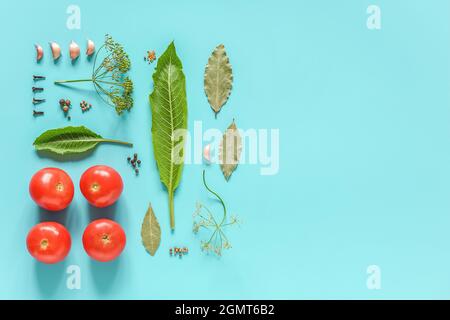 Eingelegte Tomaten. Zutaten für marinierte Tomaten und Glas auf blauem Hintergrund. Konzept kulinarische Rezept Konservierung von Gemüse in der Ernte s Stockfoto