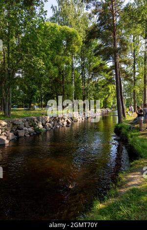 Priozersk, Russland - 10. Juli 2021: Menschen am Ufer des Flusses Vuoksa in der Nähe der Museumsfestung „Korela“ in der Stadt Priozersk in Leningrad Stockfoto