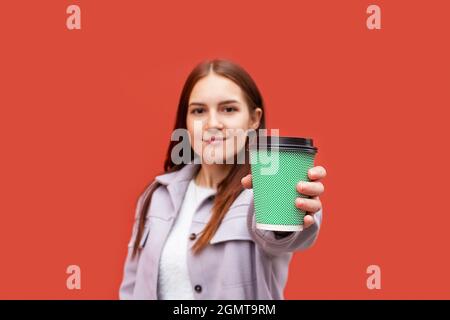 Junge Frau hält in der Hand Kaffeeglas. Stockfoto