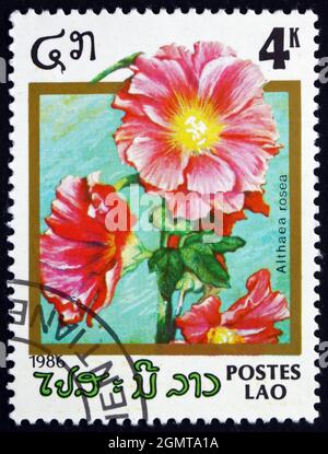 LAOS - UM 1986: Eine in Laos gedruckte Marke zeigt Hollyhock, Alcea Rosea, Ornamental Plant, um 1986 Stockfoto