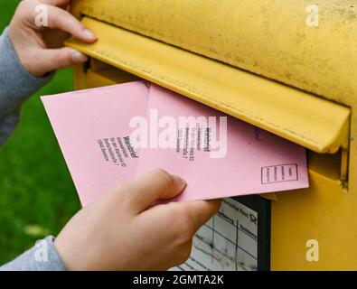 Sieversdorf, Deutschland. September 2021. Eine Person legt zwei Wahldokumente per Post in eine Mailbox der Deutschen Post. In den Umschlägen befinden sich die aktuellen Stimmzettel und die Wahlunterlagen als Briefwahl für die Bundestagswahl am Sonntag, 26. September 2021. Quelle: Patrick Pleul/dpa-Zentralbild/ZB/dpa/Alamy Live News Stockfoto