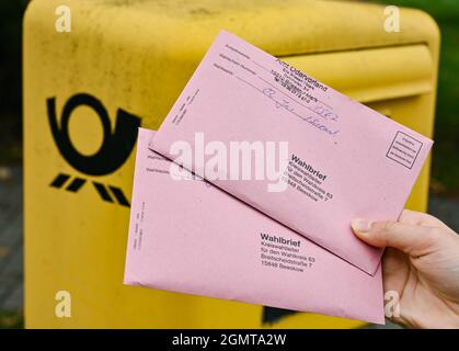 Sieversdorf, Deutschland. September 2021. Eine Person zeigt zwei Abwesenheitsstimmzettel vor einem Briefkasten der Deutschen Post. In den Umschlägen befinden sich die aktuellen Stimmzettel sowie die Wahlunterlagen als Briefwahl zur Bundestagswahl am Sonntag, 26. September 2021. Quelle: Patrick Pleul/dpa-Zentralbild/ZB/dpa/Alamy Live News Stockfoto