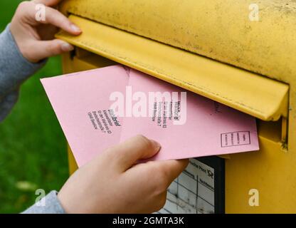 Sieversdorf, Deutschland. September 2021. Eine Person legt zwei Wahldokumente per Post in eine Mailbox der Deutschen Post. In den Umschlägen befinden sich die aktuellen Stimmzettel und die Wahlunterlagen als Briefwahl für die Bundestagswahl am Sonntag, 26. September 2021. Quelle: Patrick Pleul/dpa-Zentralbild/ZB/dpa/Alamy Live News Stockfoto