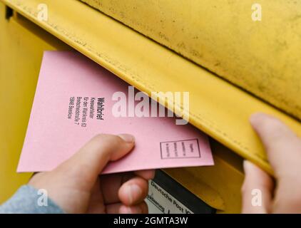 Sieversdorf, Deutschland. September 2021. Eine Person legt ihre postalischen Stimmdokumente in eine Mailbox der Deutschen Post. Der Umschlag enthält den aktuellen Stimmzettel und die Stimmdokumente als Briefwahl für die Bundestagswahl am Sonntag, 26. September 2021. Quelle: Patrick Pleul/dpa-Zentralbild/ZB/dpa/Alamy Live News Stockfoto