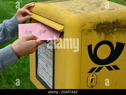 Sieversdorf, Deutschland. September 2021. Eine Person legt zwei Wahldokumente per Post in eine Mailbox der Deutschen Post. In den Umschlägen befinden sich die aktuellen Stimmzettel und die Wahlunterlagen als Briefwahl für die Bundestagswahl am Sonntag, 26. September 2021. Quelle: Patrick Pleul/dpa-Zentralbild/ZB/dpa/Alamy Live News Stockfoto