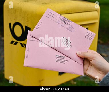 Sieversdorf, Deutschland. September 2021. Eine Person zeigt zwei Abwesenheitsstimmzettel vor einem Briefkasten der Deutschen Post. In den Umschlägen befinden sich die aktuellen Stimmzettel sowie die Wahlunterlagen als Briefwahl zur Bundestagswahl am Sonntag, 26. September 2021. Quelle: Patrick Pleul/dpa-Zentralbild/ZB/dpa/Alamy Live News Stockfoto