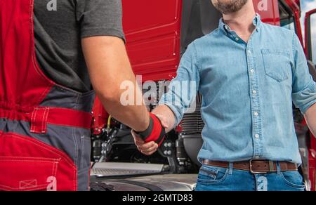 LKW-Fahrer und seine mechanische Hand zittern vor dem modernen Semi-Truck-Traktor. Thema Schwertransportindustrie. Stockfoto