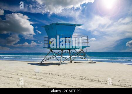 Der legendäre südkalifornische Rettungsschwimmer-Turm steht in Blau am weißen Sandstrand Coronado Beach mit dramatischen Wolken in der Nähe von San Diego, CA, USA Stockfoto