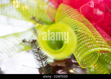 Abstrakter Feiertagshintergrund aus grünem und rotem Band mit sehr flachem Fokus. Stockfoto