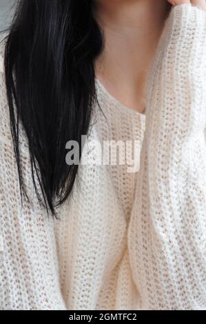 Nahaufnahme der Brunnete Frau in weißem Strickpullover Stockfoto