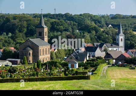 Deutschland, Wuelfrath, Wuelfrath-Duessel, Bergisches Land, Niederbergisches Land, Niederberg, Rheinland, Nordrhein-Westfalen, NRW, Panoramablick auf Duessel und die hügelige Landschaft, vor dem Friedhof, links die evangelische Kirche, rechts die katholische Kirche St. Maximin, romanische, Pfeilerbasilika Stockfoto