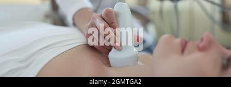 Der Arzt führt eine Ultraschalluntersuchung der Schilddrüse des Patienten durch Stockfoto