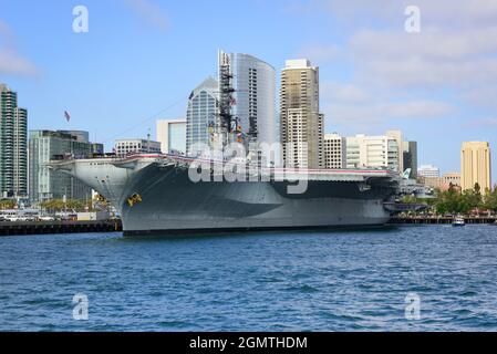 Die USS Midway, das historische Schlachtschiff des Flugzeugträgers, jetzt ein Museum, schwimmt im San Diego Hafen mit der Skyline der Innenstadt im Hintergrund, San Dieg Stockfoto