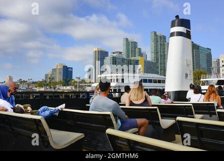 Rückansicht der Passagiere auf dem Open-Air-Deck des Cabrillo, der San Diego Ferry, mit Anlegestelle im modernen Skyline-Hintergrund, San Diego, CA Stockfoto