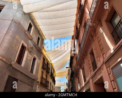 Sevilla, Andalusien, Spanien - 31. Mai 2016; keine Menschen im Blick. Stoffmarkisen schützen Käufer und Fußgänger vor der heißen Sommersonne in der Calle Sierpes Stockfoto