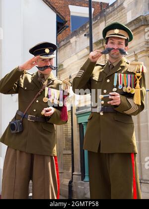 St Albans, England - 11. September 2013 Straßenkünstler, die als karikaturhafte Blechbläser der British Army agieren, komplett mit gormlosen Ausdrücken, wirbelnd Stockfoto