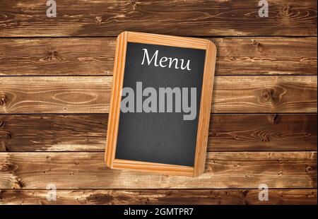 Gealtertes Menü Tafel an einer hölzernen Wand Stockfoto
