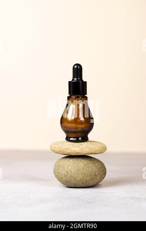 Eine braune Kosmetikflasche aus Natursteinen auf dem Podium. Natürliche Bio-Kosmetik, Mockup Stockfoto
