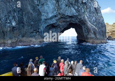 Bay of Islands, Neuseeland - 12. Mai 2012 Touristen in einem Sightseeing-Boot haben die Möglichkeit, das Hole in the Rock, einen berühmten erodierten Felsbogen, aus nächster Nähe zu sehen Stockfoto