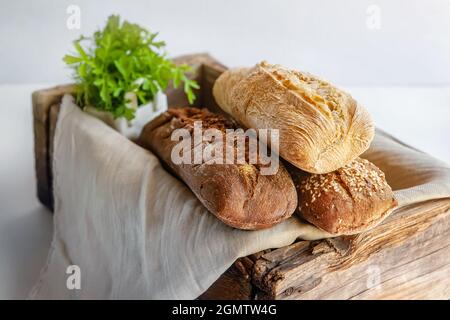 Brotauswahl in einer alten Holzkiste. Verschiedene Arten von Grüns für Brot. studiofoto. Stillleben. Stockfoto