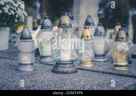 Brennende Kerzen und Laternen auf Gräbern auf dem Friedhof Stockfoto