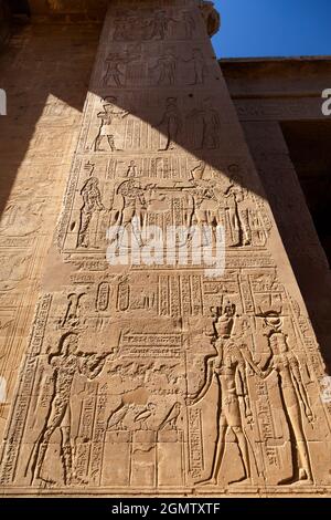 Edfu, Ägypten - 1. Dezember 2012 Mann im Schatten des Edfu-Tempels, Ägypten. Dieser wunderschöne und makellos erhaltene Tempel ist dem Falken gewidmet Stockfoto