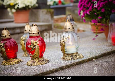 Brennende Kerzen und Laternen auf Gräbern auf dem Friedhof Stockfoto