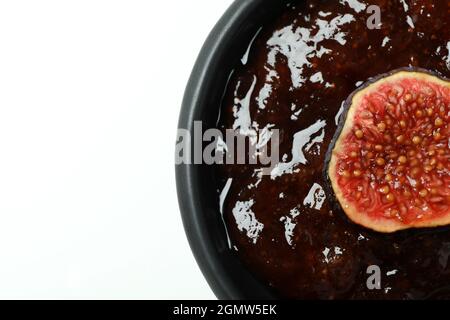 Schüssel mit Feigenmarmelade und in Scheiben auf weißem Hintergrund Stockfoto