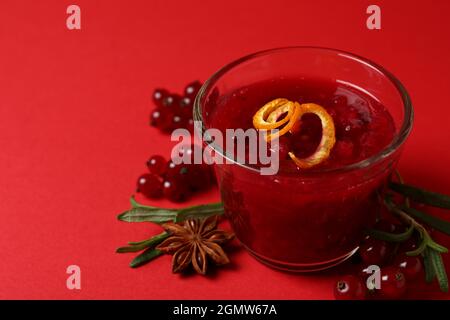 Cranberry-Sauce und Zutaten auf rotem Hintergrund Stockfoto