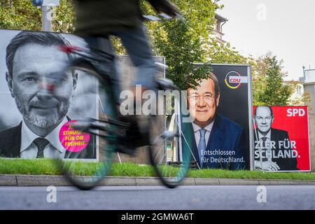 Berlin, Deutschland. September 2021. Ein Radfahrer fährt mit den Kanzlerkandidaten der SPD mit Olaf Scholz (r-l), der CDU mit Armin Laschet und dem FDP-Spitzenkandidaten Christian Lindner an großen Wahlplakaten vorbei. Am 26.09.2021 werden die deutschen Bürger aufgerufen, einen neuen Bundestag zu wählen. Quelle: Kay Nietfeld/dpa/Alamy Live News Stockfoto