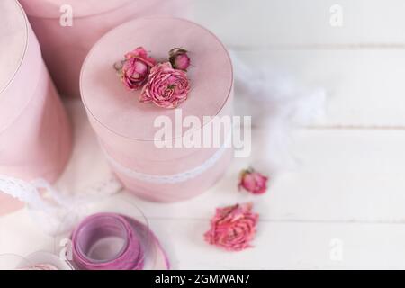 Schöne rosa runde Geschenkverpackung ist mit verengten Rosen verziert. Stockfoto