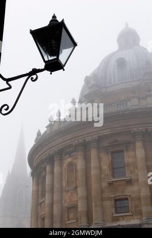 Oxford, die historische Stadt der träumenden Türme, kann bei nebelhaftem Wetter recht geheimnisvoll aussehen; halb verdeckte Türme, Statuen und gotische Türme stehen vor Dramatikern Stockfoto