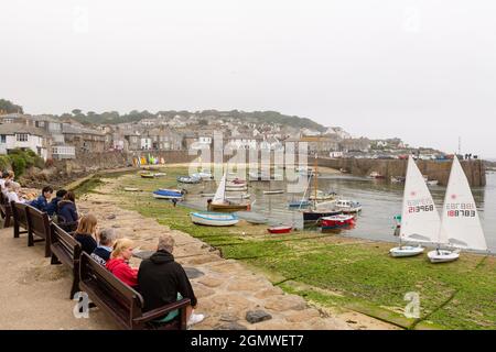 Angeln und Vergnügungsboote liegen bei Ebbe im Mousehole Harbour, Cornwall. Stockfoto