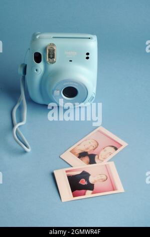 Retro-Kamera. Instant Polaroid Blue Kamera: FUJIFILM INSTAX Mini 11 Instant Film Kamera und gedruckte Bilder Stockfoto