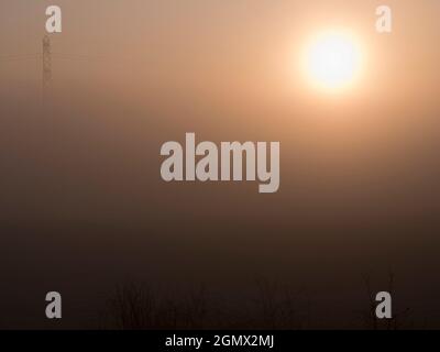 Radley Village, Oxfordshire, England - 7. Februar 2020; keine Menschen im Blick. Dieses extrem minimalistische Bild zeigt nichts anderes als die aufgehende Sonne, die man durch die Sonne sieht Stockfoto