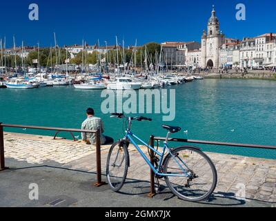 La Rochelle, Frankreich - 20. Juni 2013; ein Mann und sein Fahrrad - eine Person im Blick am Wasser. La Rochelle wurde im 10. Jahrhundert gegründet und ist eine historische Stadt Stockfoto