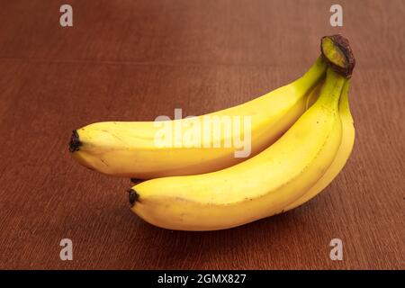 Drei reife gelbe Bananen auf dem Holztisch. Innen-Cckoseup Stockfoto